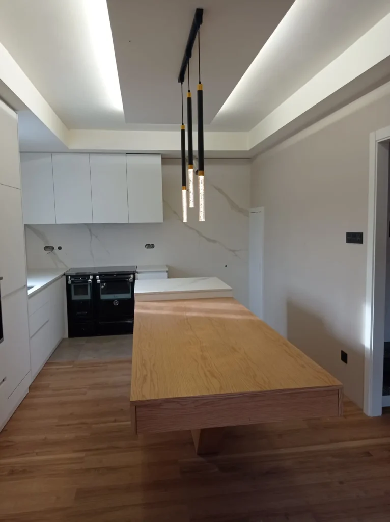 Reforma integral de cocina moderna completa con techo decorativo iluminado sobre isla