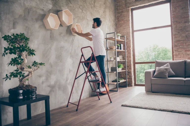 Foto De Vista De Perfil De Chico Instalando Un Estante De Pared